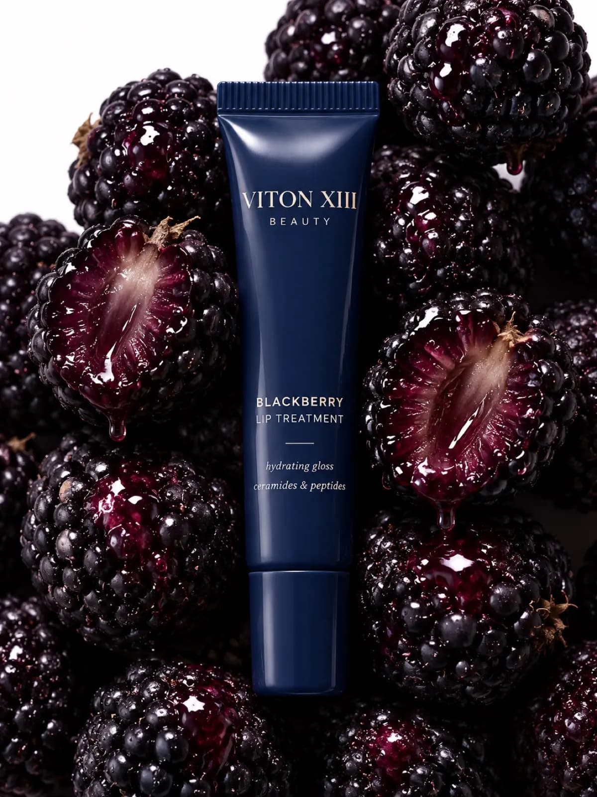AI-generated key visual: a navy VITON XIII BEAUTY blackberry lip-treatment tube among glossy blackberries, two of them cut in half