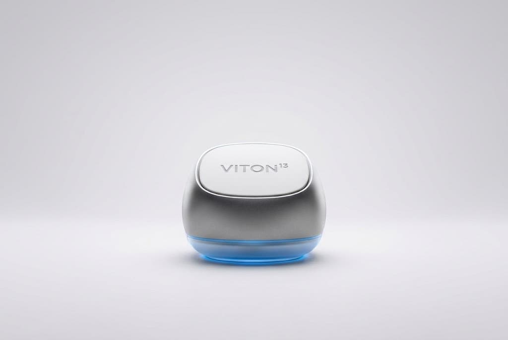 A rounded silver VITON13 device with a white top and a glowing sky-blue base